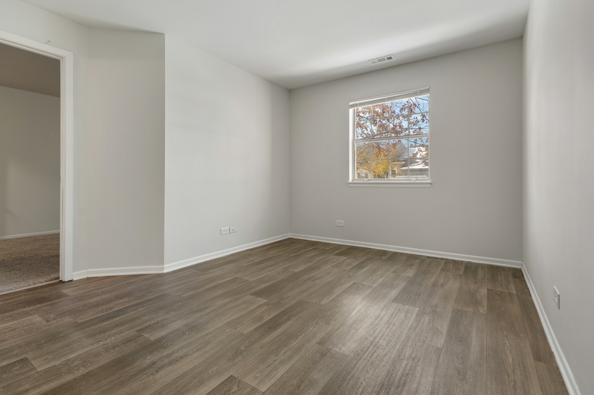96 Gant Circle, Unit B Streamwood, IL 60107 - Photo 9 of 21 an empty room with wooden floor and windows