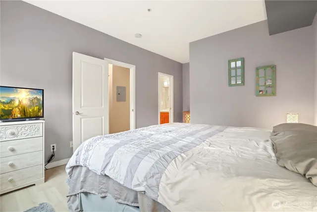 a bedroom with a bed and dresser with mirror