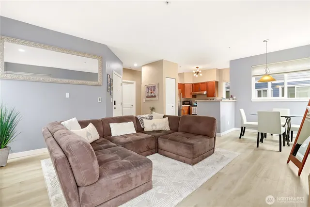 a living room with furniture kitchen view and a large window