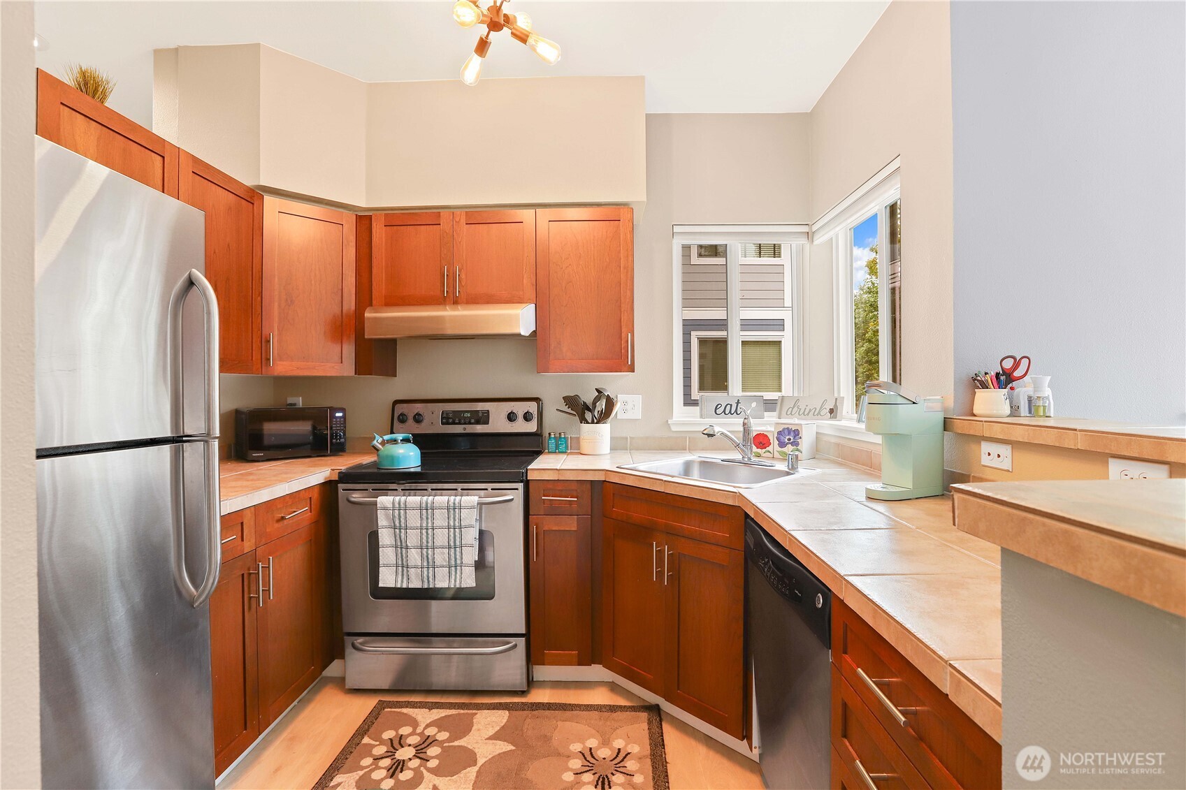 3906 243rd Place Southeast, Unit P202 Bothell, WA 98021 - Photo 7 of 17 a kitchen with stainless steel appliances a refrigerator sink and stove