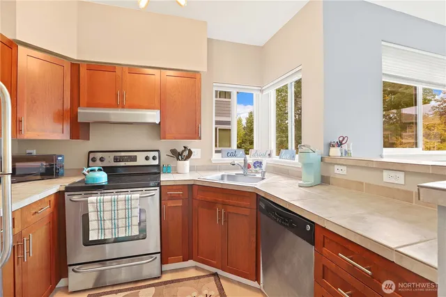 a kitchen with granite countertop a sink stove and cabinets