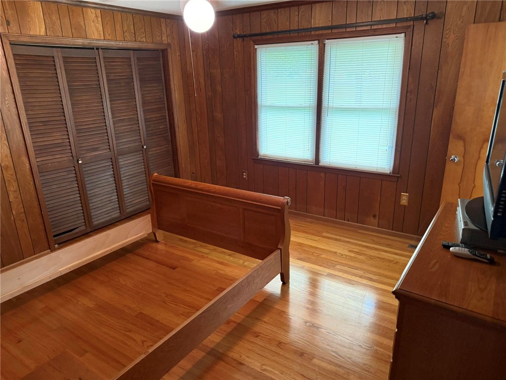 4027 Belhaven Road Belton, SC 29627 - Photo 17 of 24 Hardwood floors and a wall of louvered closet doors define this cozy sleeping space.
