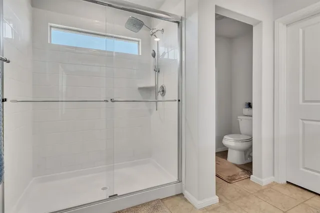 a bathroom with a granite countertop toilet and a shower