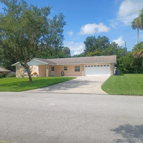 a view of a house with a big yard and large trees