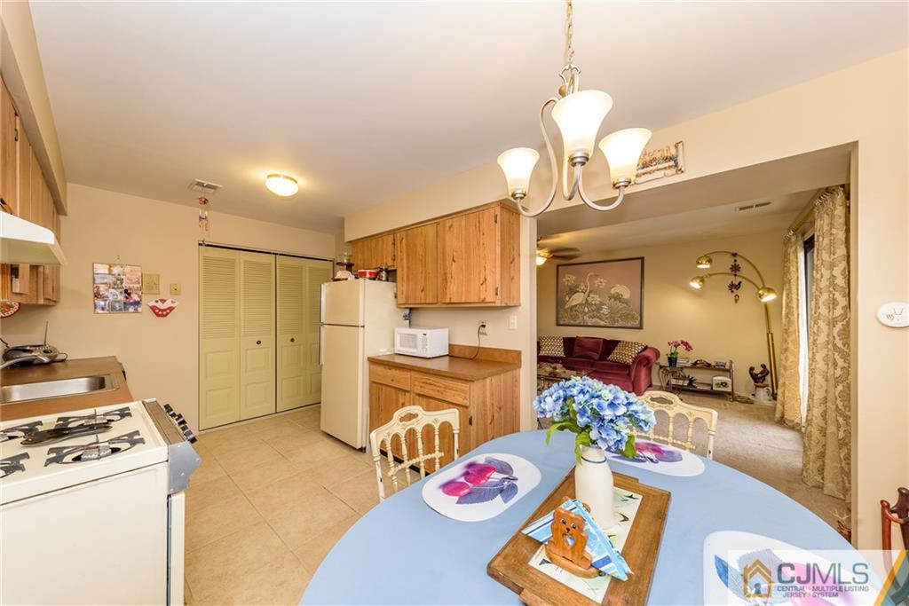 1607 Raspberry Court, Unit 1607 Edison, NJ 08817 - Photo 11 of 14 a kitchen that has a lot of cabinets a stove and a wooden floor