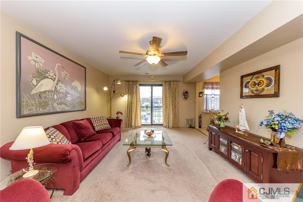 1607 Raspberry Court, Unit 1607 Edison, NJ 08817 - Photo 5 of 14 a living room with furniture ceiling fan and a rug