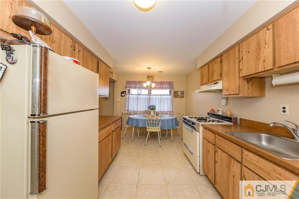 1607 Raspberry Court, Unit 1607 Edison, NJ 08817 - Photo 6 of 14 a kitchen with refrigerator and cabinets