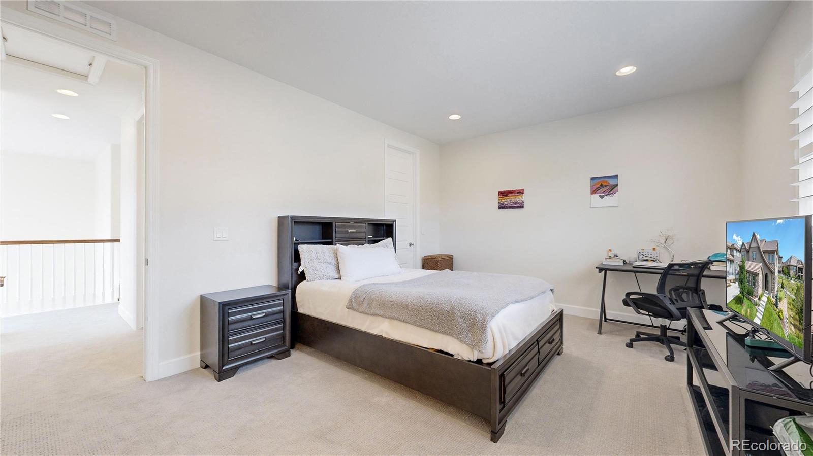 1476 Red Sun Way Highlands Ranch, CO 80126 - Photo 14 of 37 a living room with a bed furniture and a flat tv screen