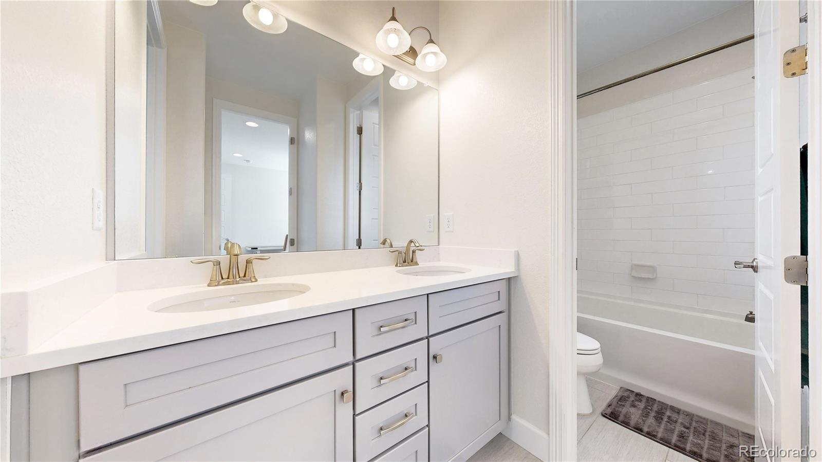 1476 Red Sun Way Highlands Ranch, CO 80126 - Photo 15 of 37 a bathroom with a double vanity sink mirror and a bathtub