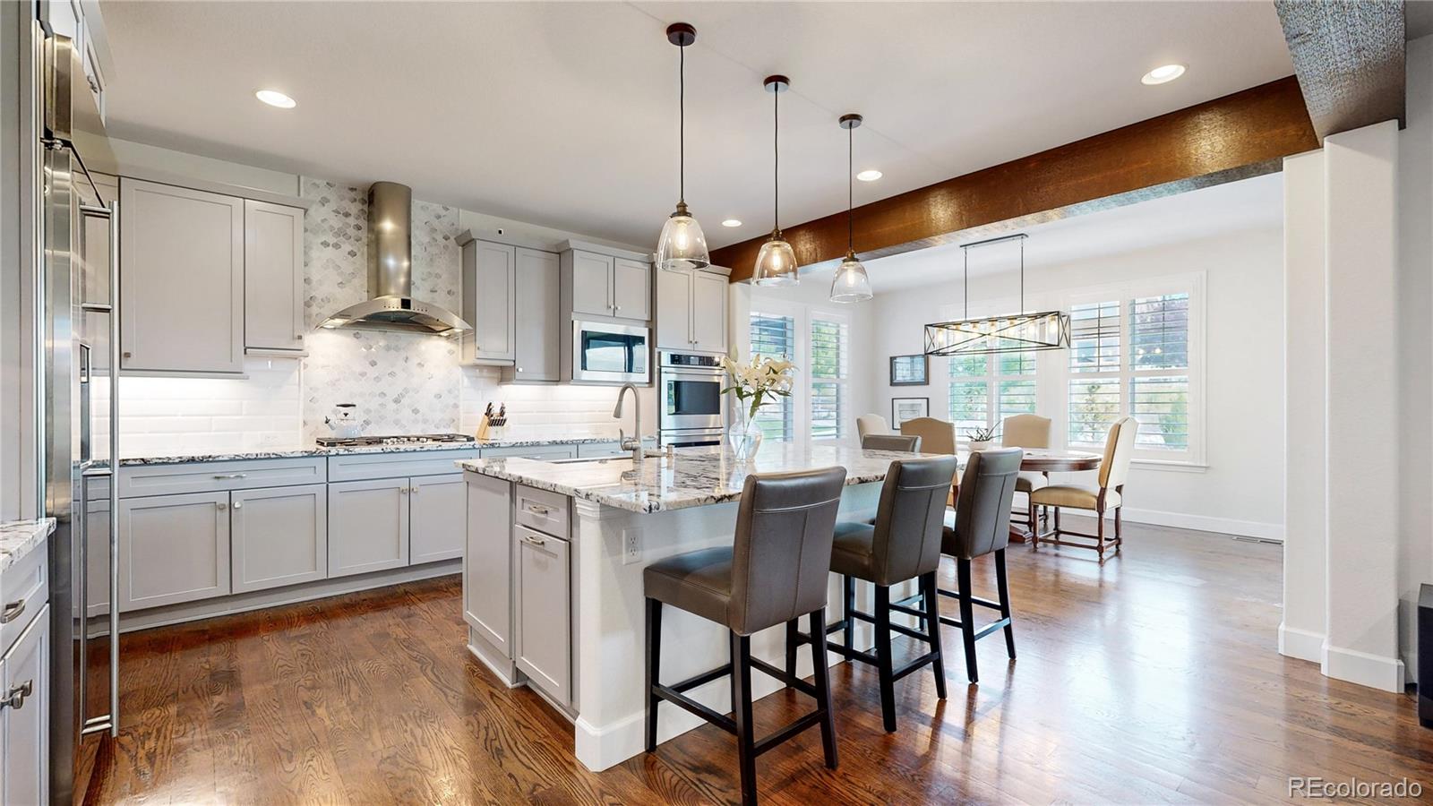 1476 Red Sun Way Highlands Ranch, CO 80126 - Photo 8 of 37 a kitchen with kitchen island granite countertop a table chairs sink and cabinets