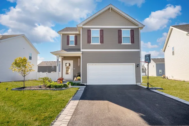 a front view of a house with a yard and garage