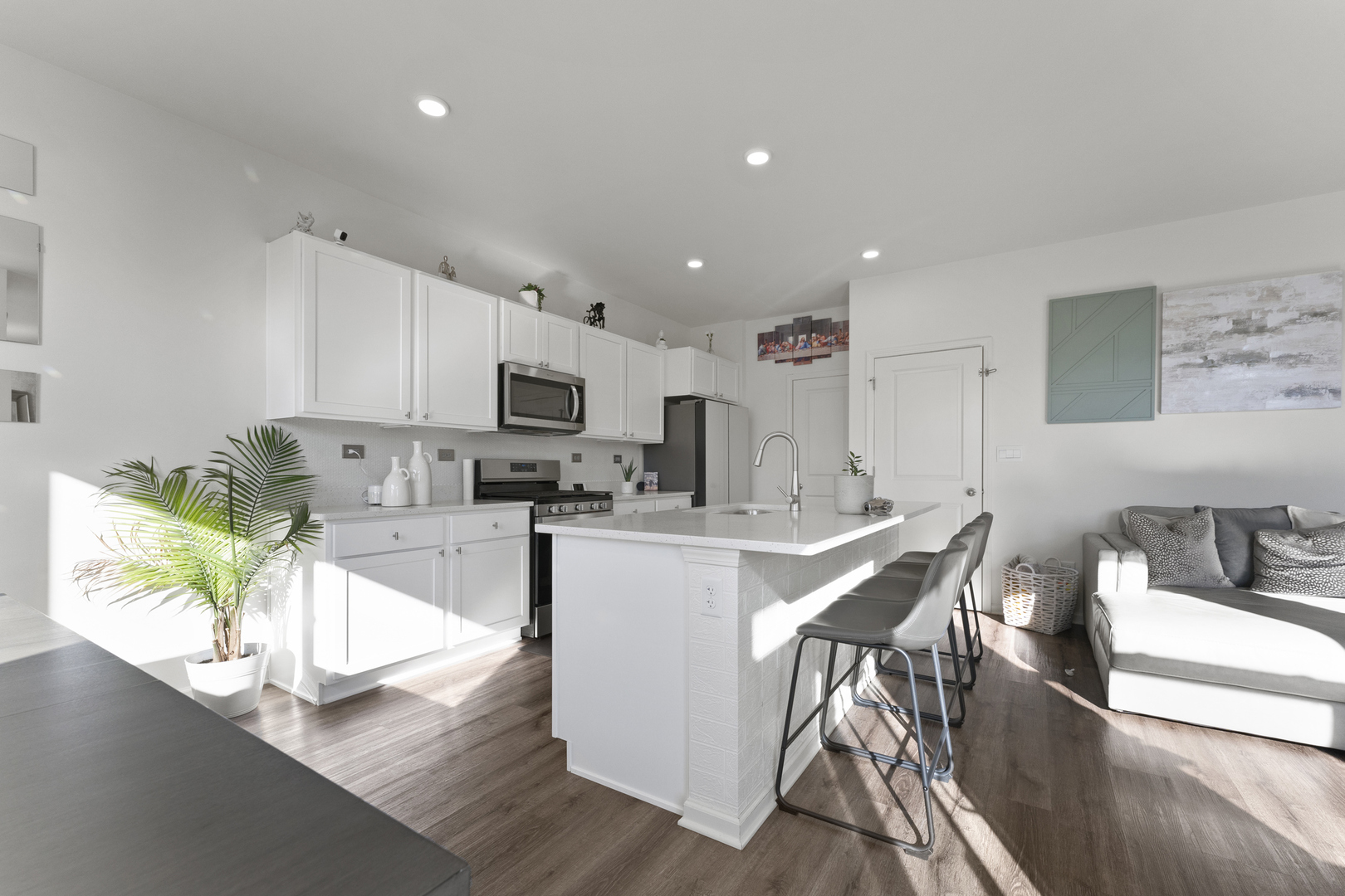 2017 Lilyana Lane Plainfield, IL 60586 - Photo 6 of 43 a kitchen with stainless steel appliances granite countertop a stove top oven a sink a dining table and chairs with wooden floor