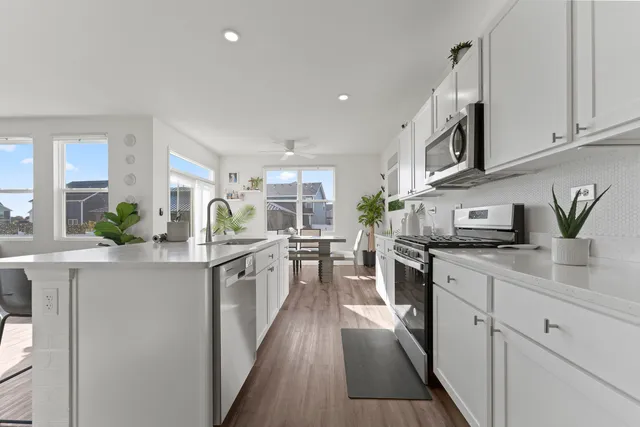 a kitchen with stainless steel appliances granite countertop white cabinets sink and stove