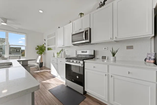 a dining room with furniture potted plants and wooden floor