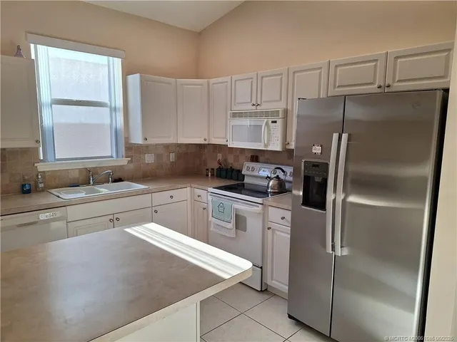 a kitchen with a refrigerator a sink and cabinets