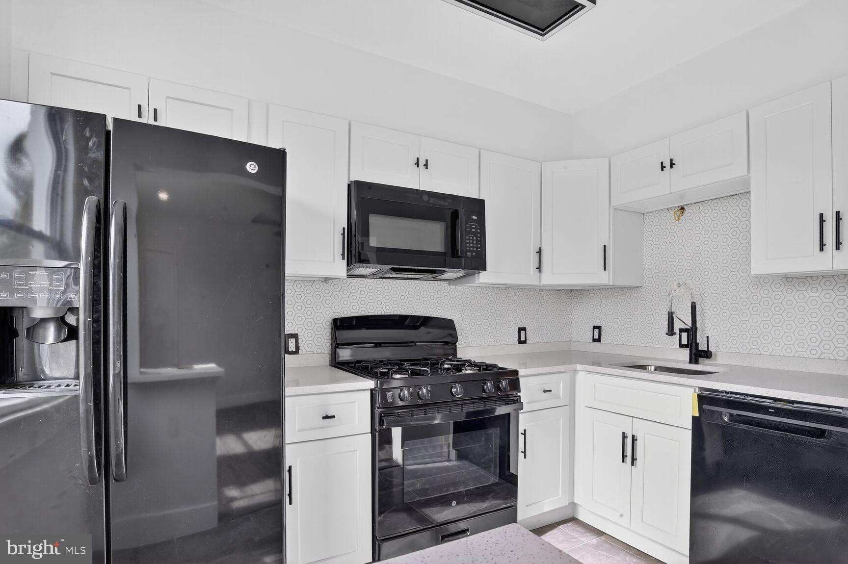a kitchen with stainless steel appliances a stove a refrigerator and a sink