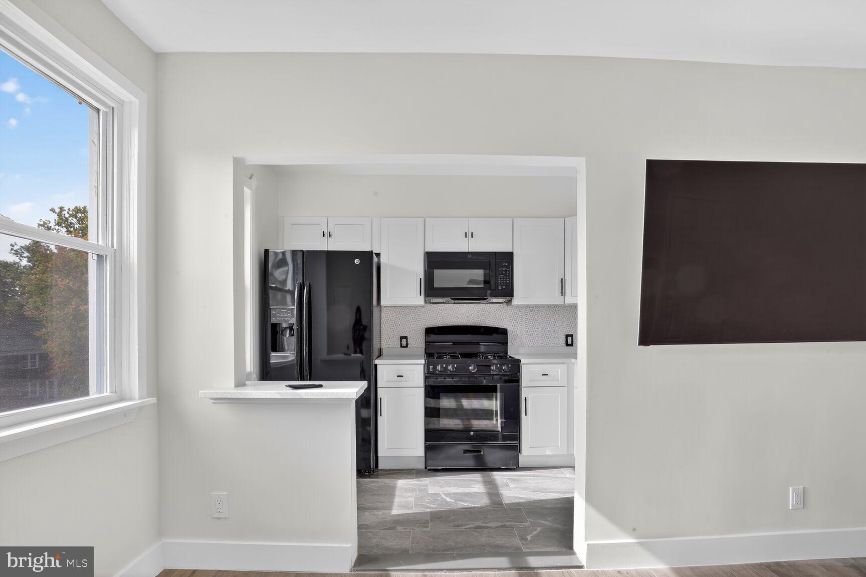 1116 Gleneagle Road, Unit 2 Baltimore, MD 21239 - Photo 14 of 18 a kitchen with stainless steel appliances a refrigerator and a stove top oven