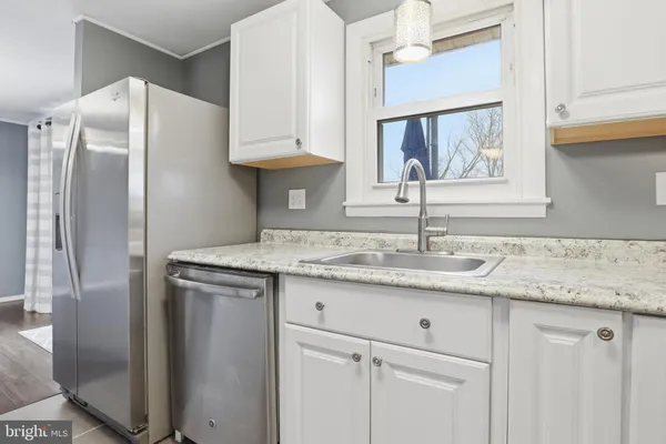 a kitchen with stainless steel appliances granite countertop a sink and a refrigerator