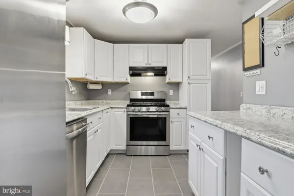 a kitchen with stainless steel appliances granite countertop a stove sink and cabinets