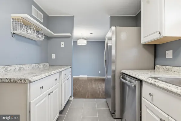 a kitchen with granite countertop a sink and a refrigerator