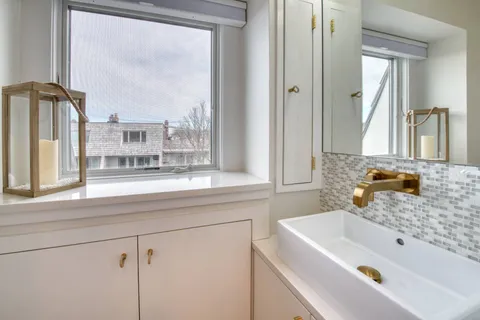 a bathroom with a tub sink and mirror