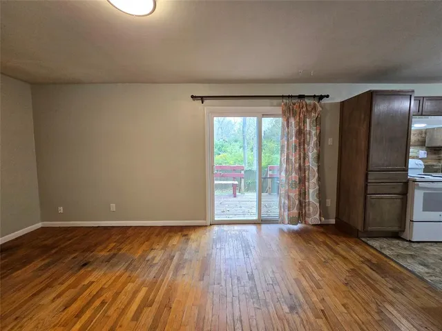 a view of a room with wooden floor and a window
