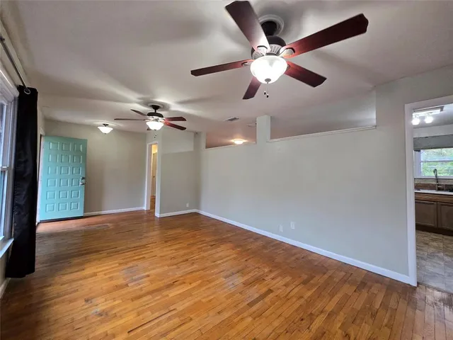 a view of an empty room with wooden floor