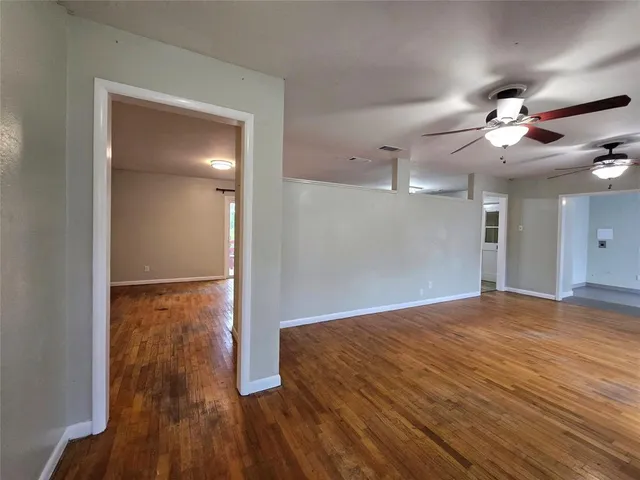 a view of a room with wooden floor and a ceiling fan