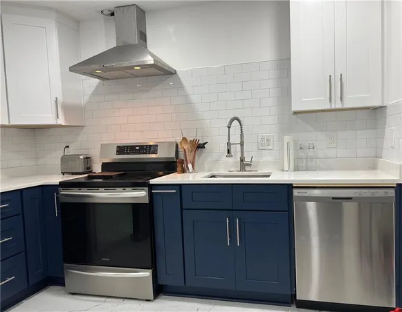 a kitchen with stainless steel appliances a stove a sink and cabinets