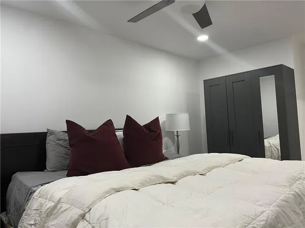 a bedroom with a bed and a large mirror