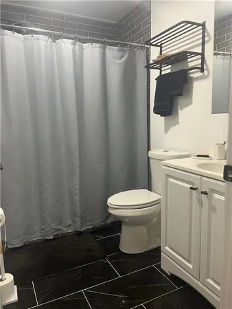 a white toilet sitting next to a shower curtain