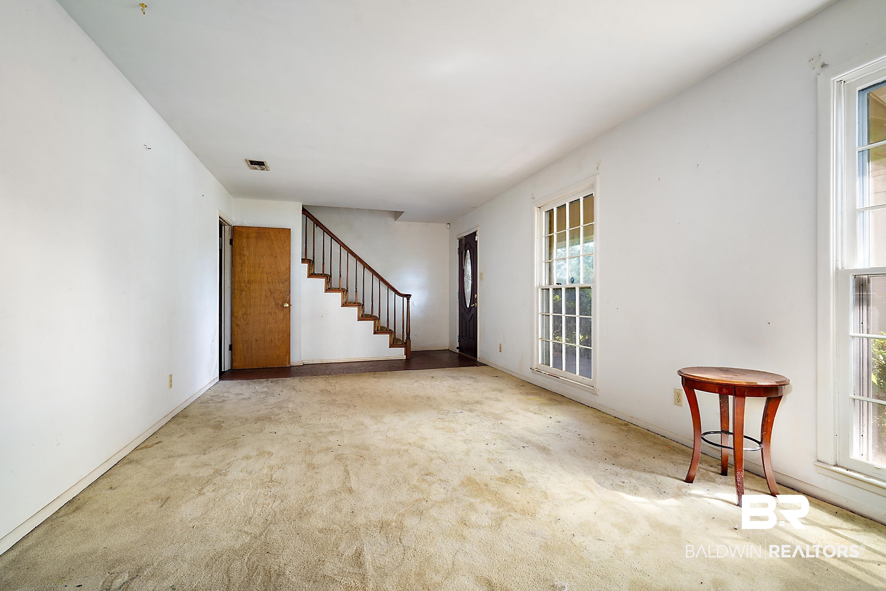 576 Markham Drive Mobile, AL 36609 - Photo 4 of 18 Carpeted spare room with healthy amount of natural light and stairs