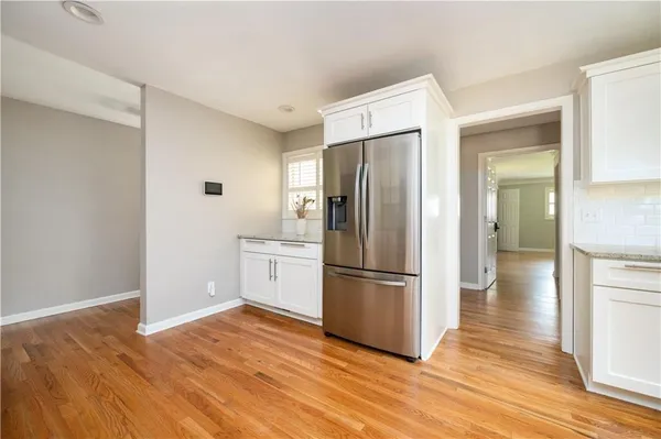 a kitchen with wooden floor and refrigerator