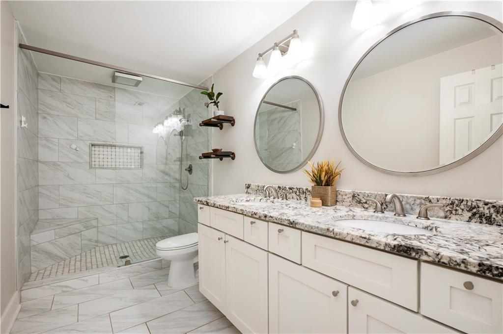 3850 Beya Way Atlanta, GA 30340 - Photo 9 of 18 a bathroom with a granite countertop toilet a sink and a mirror