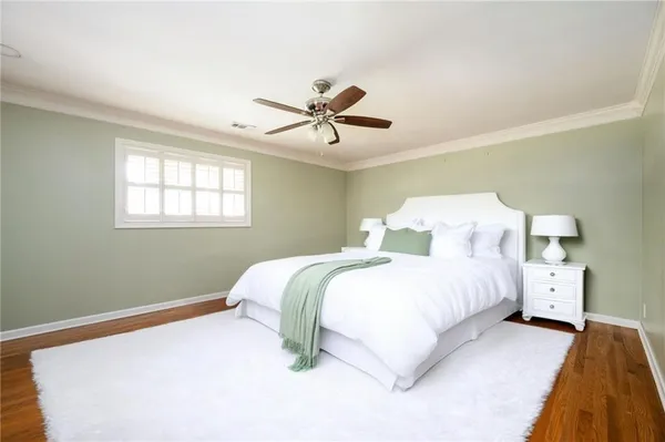 a bedroom with a bed chandelier and a window