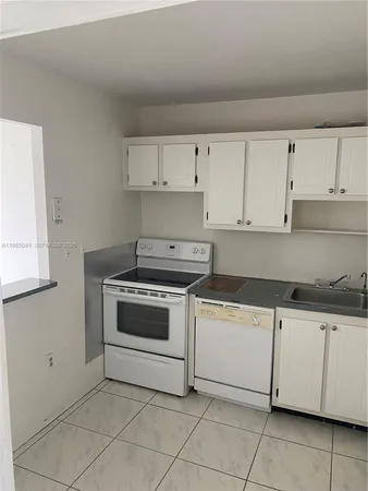a kitchen with granite countertop white cabinets and white appliances