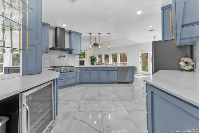 a kitchen with stainless steel appliances a refrigerator a stove and a sink