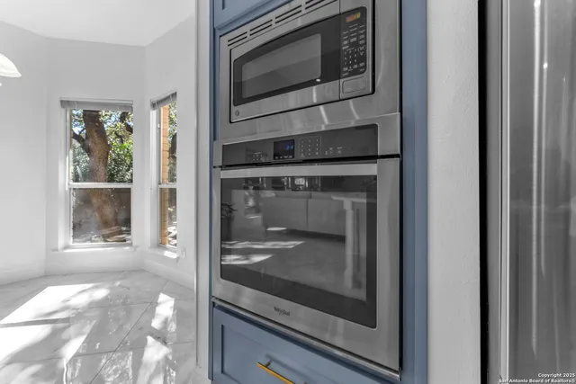 a view of a room with a large window and chandelier