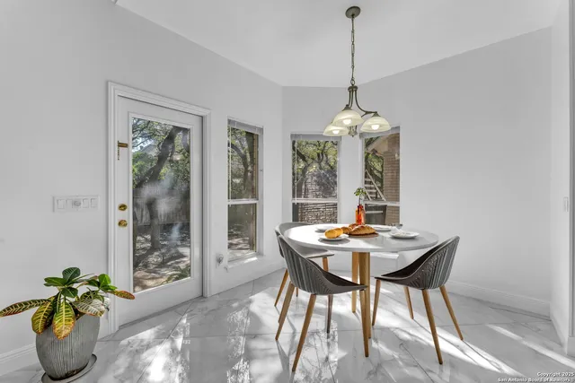 a dining room with furniture potted plants and wooden floor