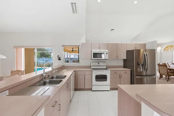 a living room with stainless steel appliances furniture a fireplace and a flat screen tv