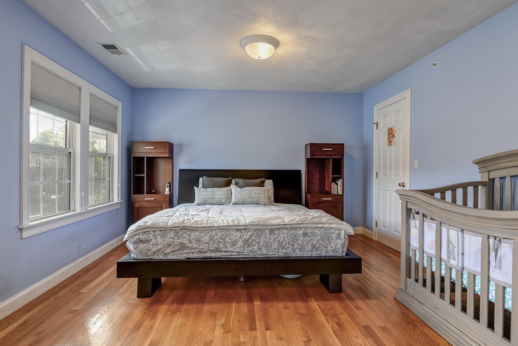 58 Webster Street, Unit 58 Newton, MA 02465 - Photo 15 of 28 a bedroom with a bed and a window with wooden floor