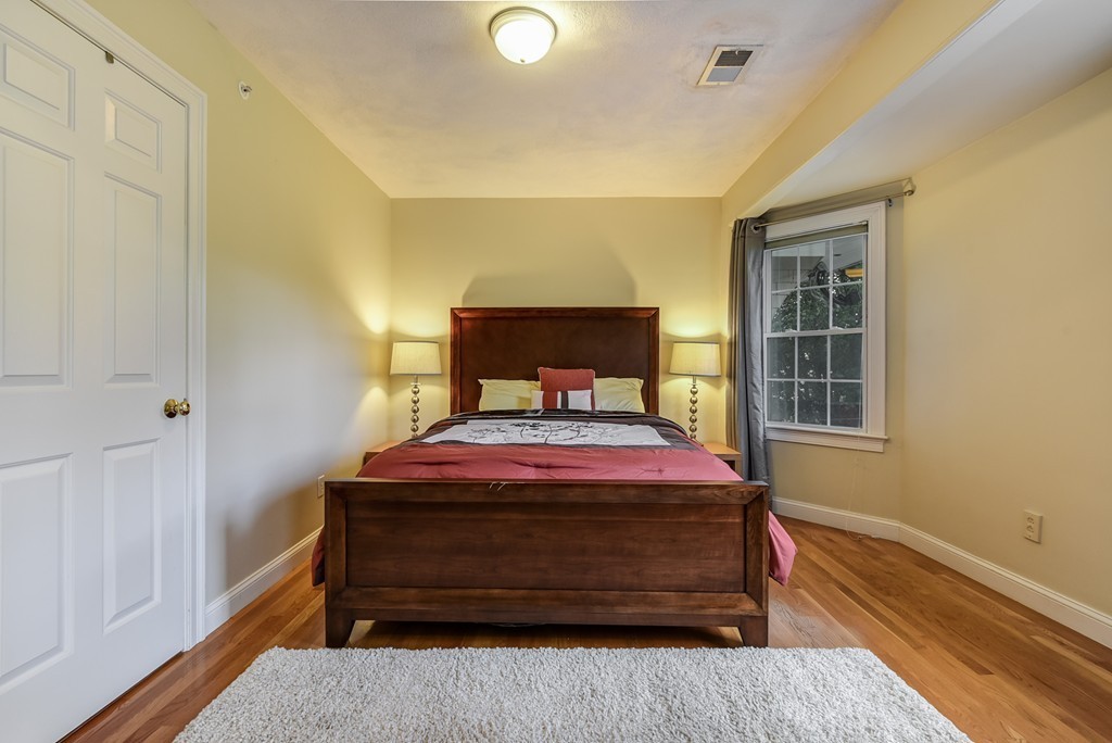 58 Webster Street, Unit 58 Newton, MA 02465 - Photo 17 of 28 a bedroom with a bed and wooden floor