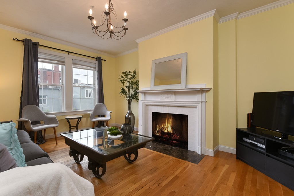 58 Webster Street, Unit 58 Newton, MA 02465 - Photo 10 of 28 a living room with furniture flat screen tv and a fireplace
