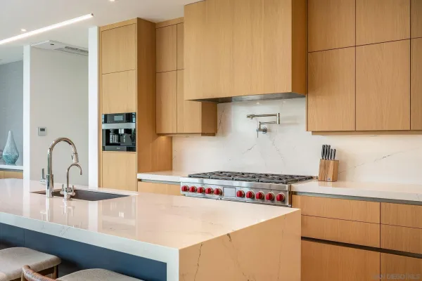 a kitchen with stainless steel appliances a sink a stove and white cabinets
