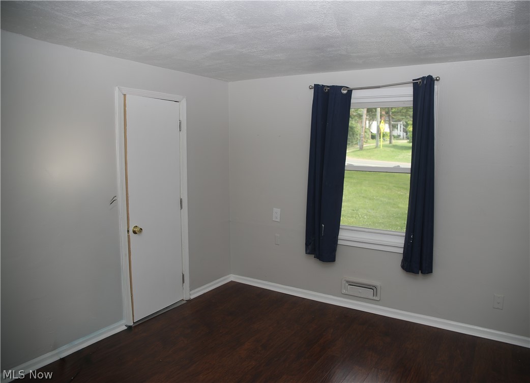 1087 Krumroy Road Akron, OH 44306 - Photo 6 of 23 Interior room featuring wood-finish flooring, light grey painted walls, and white baseboards