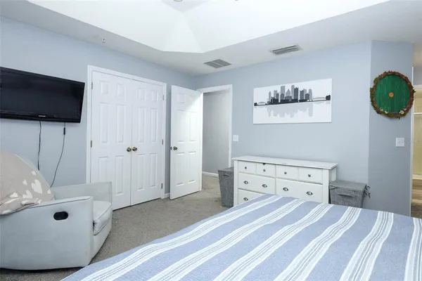 a spacious bedroom with a bed and a flat screen tv