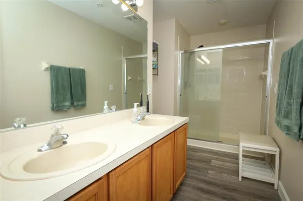 a bathroom with a sink double vanity mirror and a shower
