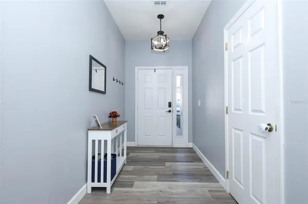 a view of a hallway with wooden floor and front door