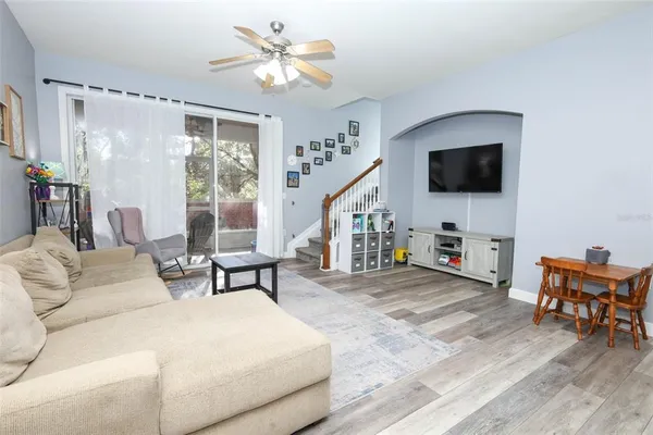 a living room with furniture a flat screen tv and a large window