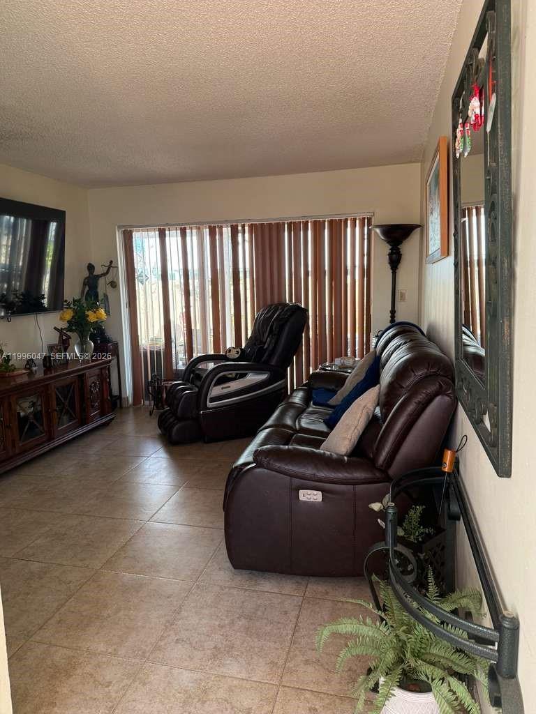7477 Northwest 167th Street Hialeah, FL 33015 - Photo 20 of 24 a living room with furniture gym equipment and a large window
